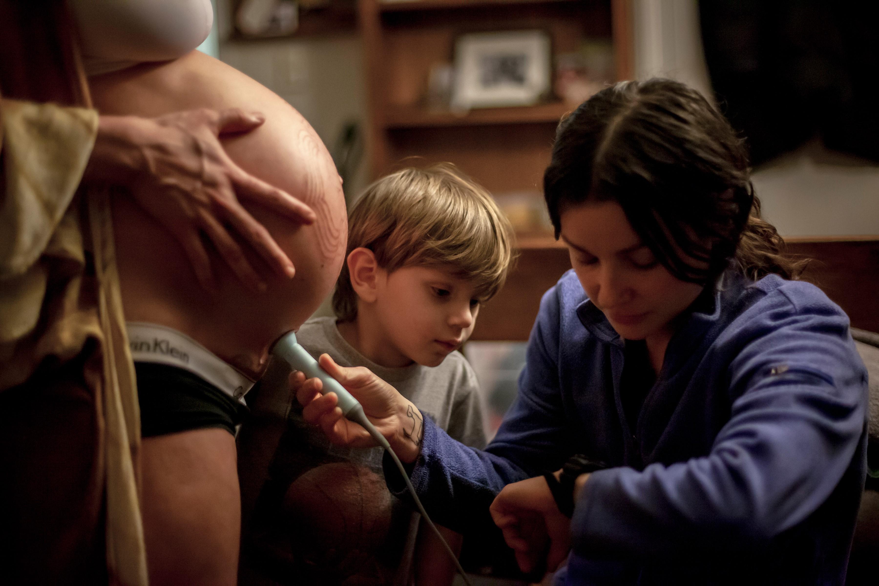 midwife checking a baby's heartbeat with a Dopler