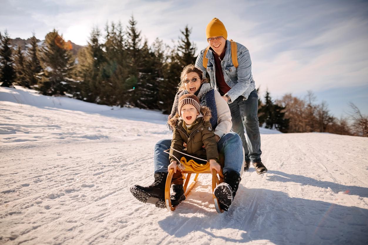 Family having fun sledding 