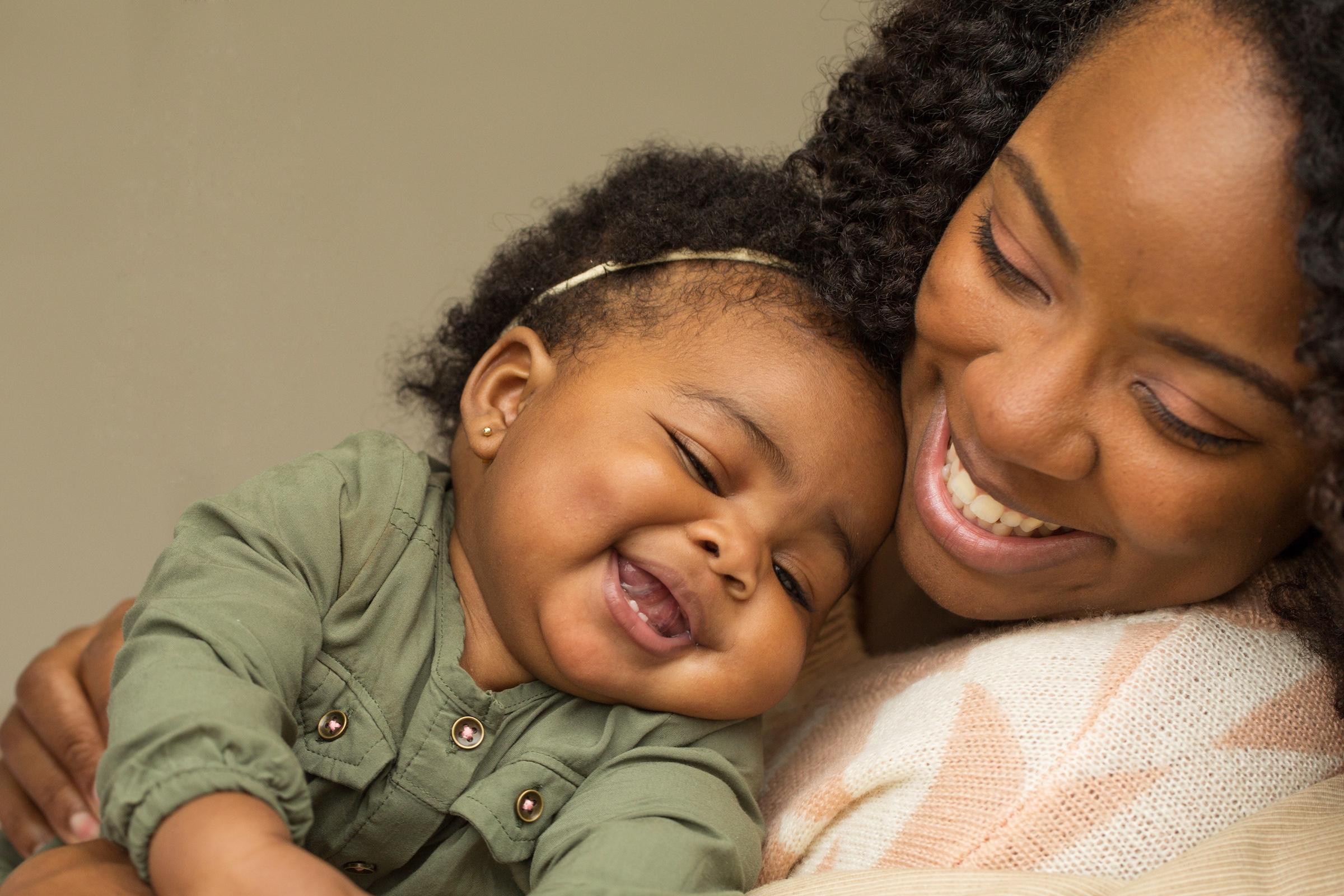 Black mother snuggles her baby