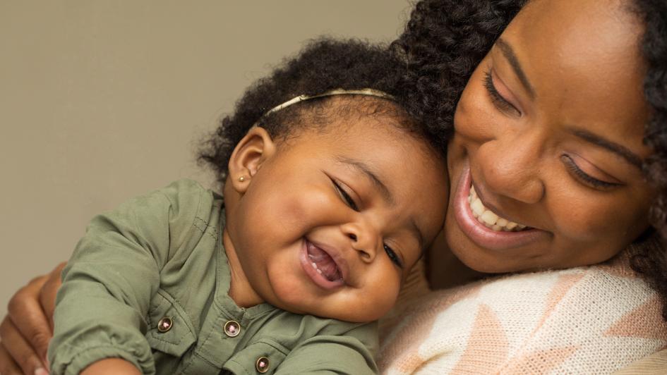 Black mother snuggles her baby